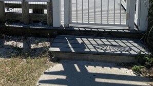 A gated entrance with a 'NO TRESPASSING' sign, a wooden signboard listing retreat names, and a view of the beach and ocean. - MERMAID - Largest Heated Pool, Walk to Private Beach, GolfCart, Pet Friendly. (Miramar Beach)