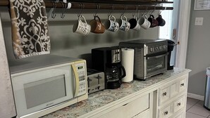 A kitchen with a microwave, coffee maker, and oven on the counter, with a towel hanging on the door handle. - Visit beautiful Dayton, Tennessee! (Dayton)