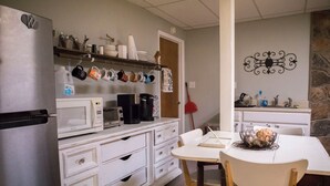 A kitchen with a refrigerator, microwave, coffee maker, and a dining table with chairs. - Visit beautiful Dayton, Tennessee! (Dayton)