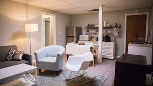 A compact living space with a sofa, a rocking chair, a dining table, and a kitchenette area. - Visit beautiful Dayton, Tennessee! (Dayton)