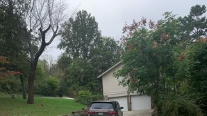 A residential driveway with a parked car, a garage, and surrounding greenery. - Visit beautiful Dayton, Tennessee! (Dayton)