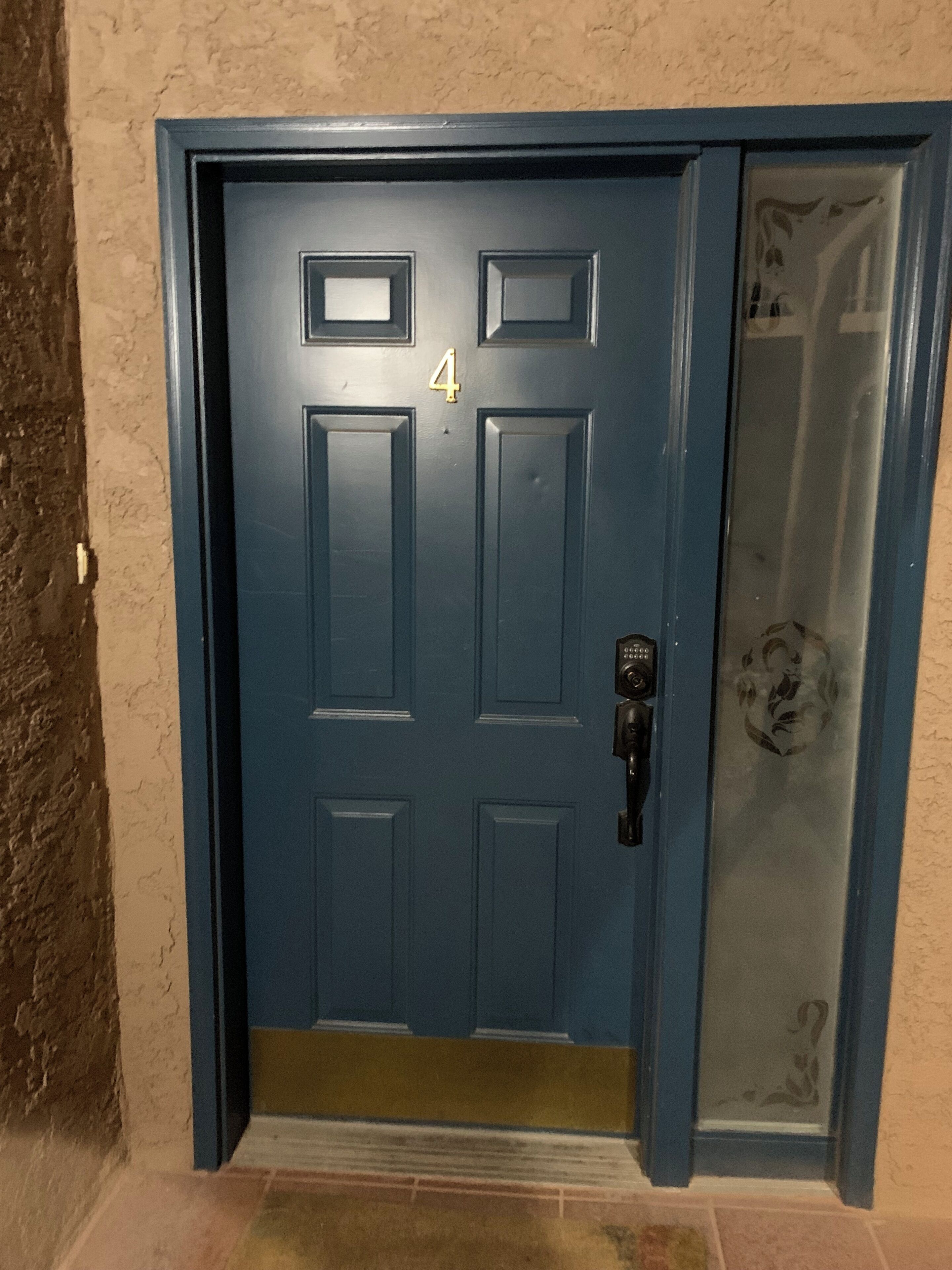 A blue door with the number 4, a glass panel, and a doorbell.