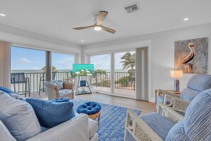 A spacious living room with a large TV, comfortable seating, and a balcony with a view. - Rx: Paradise updated 2bed/2.5bath townhouse style condo with open water views, shared pool & dockage (Marathon)