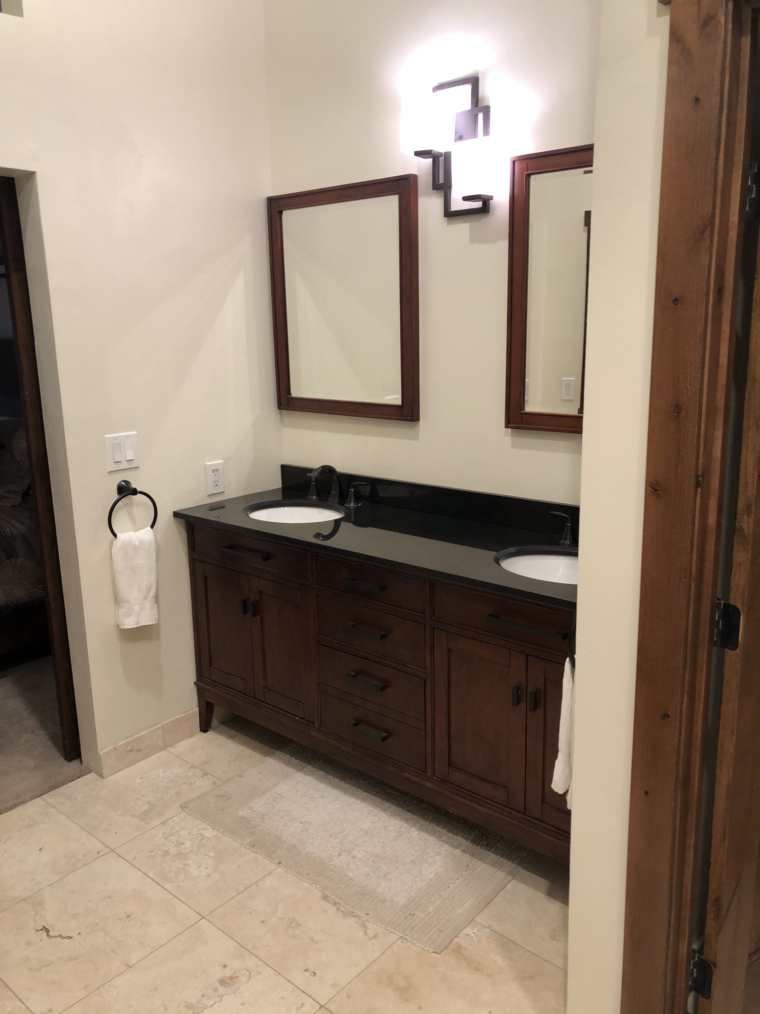 A bathroom with two sinks, a mirror, and a towel rack.