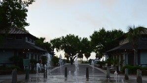 Uma fonte em um pátio com edifícios de ambos os lados.