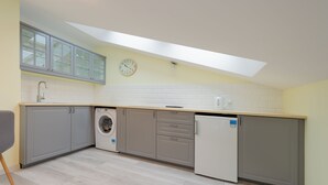 Una cocina moderna con gabinetes grises, lavadora y lavavajillas.