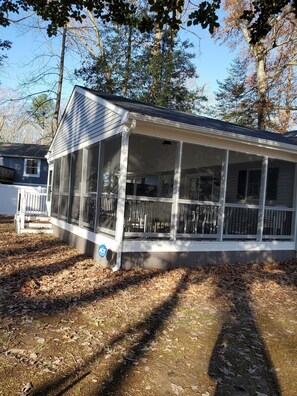 A covered porch with large windows, a white railing, and a blue sign indicating ADA compliance.