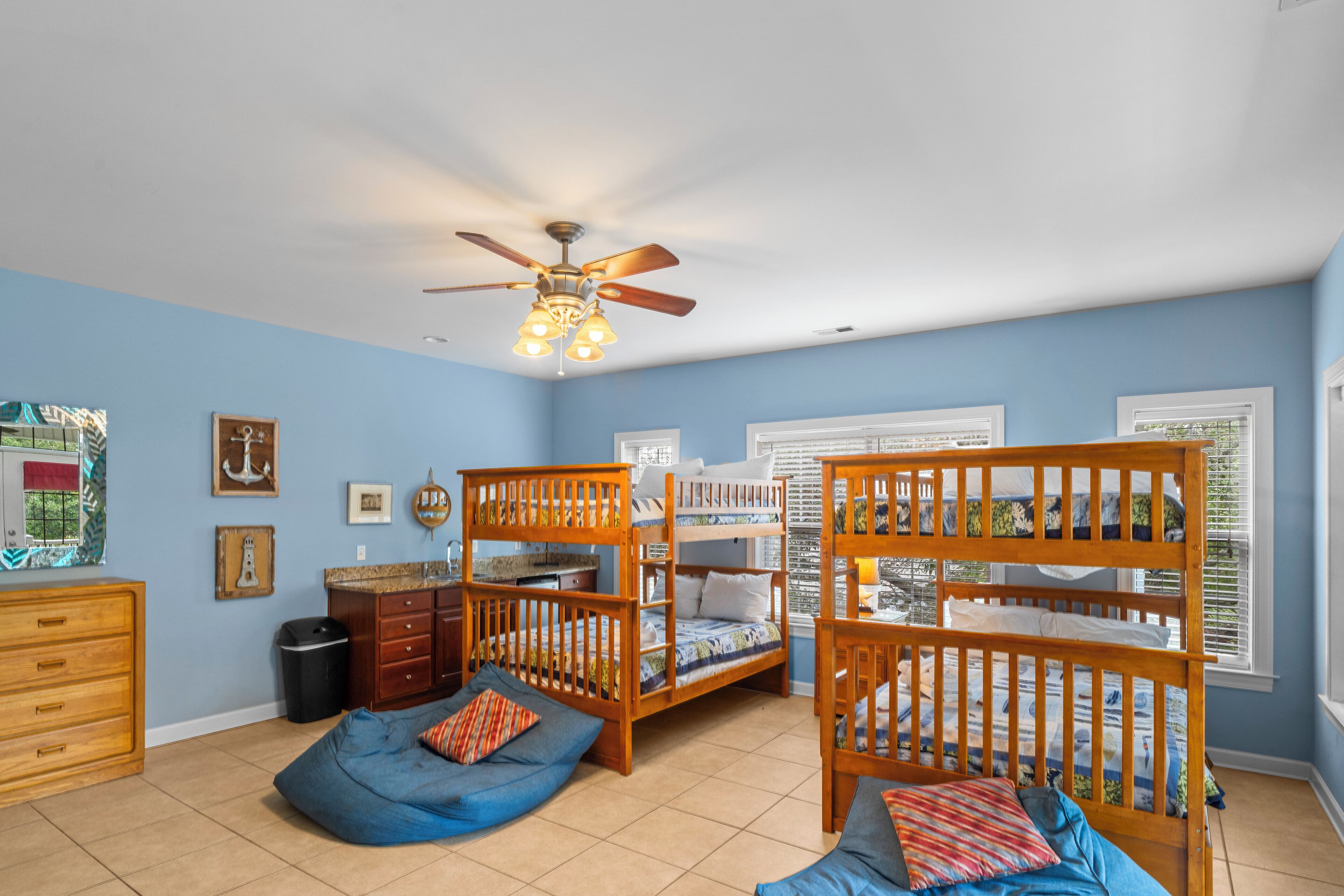 A child's bedroom with bunk beds, a ceiling fan, and a window with blinds.