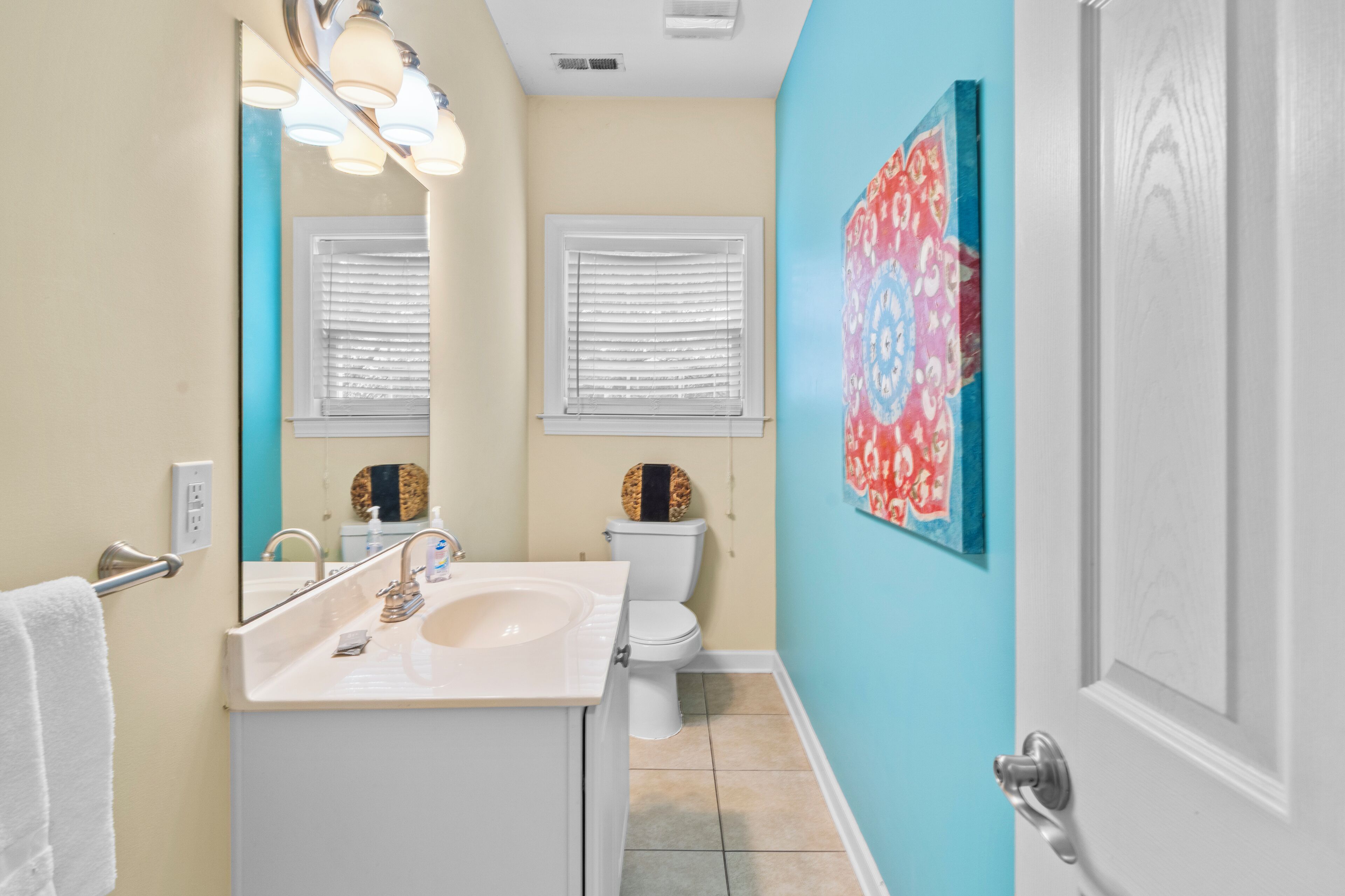 A bathroom with a sink, toilet, and a mirror.