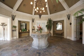 A spacious lobby with a stone floor, a central fountain, and a chandelier. - Luxury Rental in North Scottsdale-2 Bed/2Bath (Scottsdale)