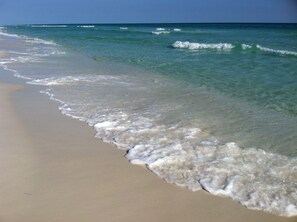 Ein Strand mit klarem Wasser und sanften Wellen.