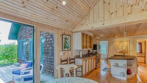 Une cuisine moderne avec des meubles en bois, un îlot central et un coin repas comprenant une table et des chaises.