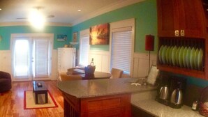 A kitchen with wooden cabinets, a central island, and a dining area with a table and chairs. - Luxury WATERFRONT condo overlooking pool, 5 mins to Dog Island, FREE boat slip. (Carrabelle)