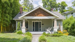 A single-story house with a front porch, a chimney, and a pathway leading to the entrance.