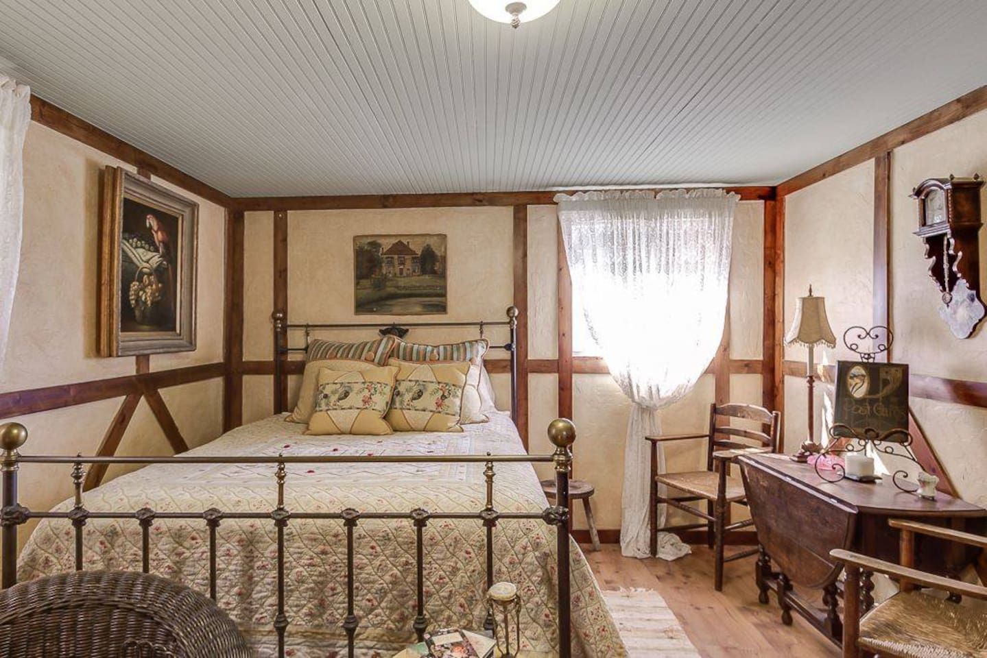 Une chambre à coucher de style traditionnel, avec un lit à baldaquin, un bureau en bois et une chaise.