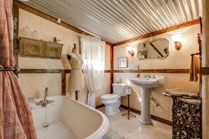 A bathroom with a bathtub, toilet, and sink. - Last Outpost – Sophies | Cozy Cottage for Two (Bandera)