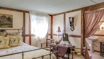 A bedroom with a bed, a desk, a chair, a clock, and a window with curtains.