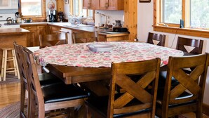 Un intérieur en bois comprenant une table à manger, des chaises et un lustre.