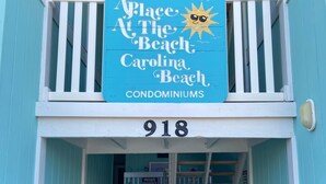 A turquoise building with a sign reading "Place at The Beach Carolina Beach Condominiums" and the number 918. - Oceanfront 2BR/2Bath Condo in Carolina Beach NC  (Carolina Beach)