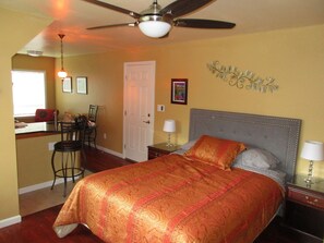 A bedroom with a bed, a desk, and a chair.