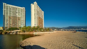 Un hotel frente a la playa con piscina, acceso directo a la costa y vistas a la ciudad y las montañas.