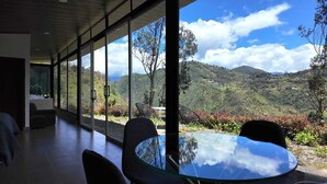 A modern interior with large windows offering a view of a mountainous landscape.