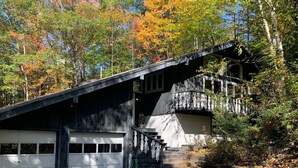 A two-story building with a garage and a staircase leading to a balcony.