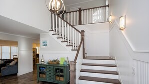 A staircase with wooden steps and white railings, leading to an upper floor.