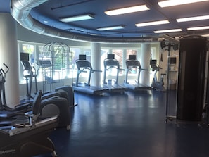 A gym with treadmills, elliptical machines, and a weight machine.