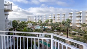 Un hôtel doté de nombreux balcons, d’une piscine et de palmiers.