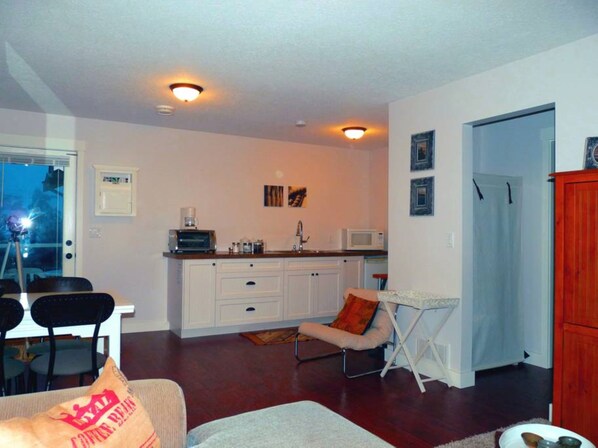 A compact living space with a kitchenette, dining area, and a small seating area. - Potters View Guesthouse, Parksville (Parksville)