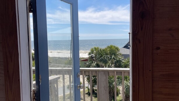 A wooden door leading to a balcony with a view of the beach. -  The Beach House on Florida's Forgotten Coast (St. Joe)