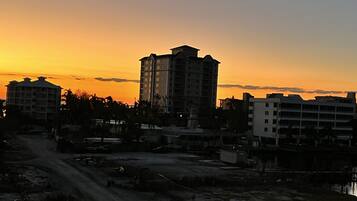 A cityscape at sunset with buildings silhouetted against the sky.