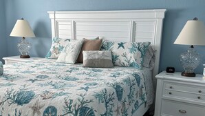 A bedroom with a bed, nightstands, and a wall clock. - ~ Music by the Sea ~ On the Beach ~ Hear the Ocean Surf~ (Indian Rocks Beach)