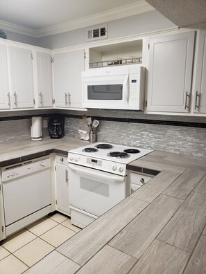 Enjoy cooking in this well-equipped kitchen with a stove, microwave, dishwasher, and coffee maker.