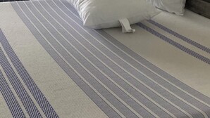 Ein Hotelzimmer mit einem Bett, zwei Kissen, einem Kopfteil und einem Vogelbild an der Wand.