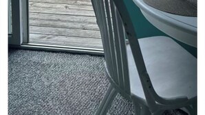 Ein Balkon mit Blick auf einen Swimmingpool, einem Stuhl und einem Tisch.