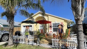 A house with a white picket fence, a red umbrella, and a scarecrow decoration. - 10% discounts Aug, Sept  (St Augustine)