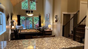 A kitchen with a granite countertop, a dining area with a table and chairs, a ceiling fan, and a view of the outdoors through large windows. - Pet Friendly 2 bedroom plus loft, in Parksville's beautiful resort area (Parksville)