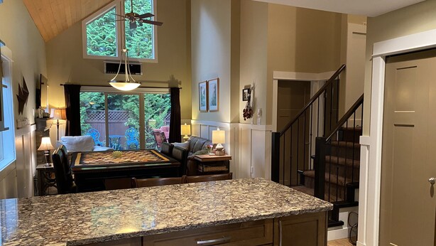 A kitchen with granite countertops, wooden cabinets, and a dining area with a table and chairs. - Pet Friendly 2 bedroom plus loft, in Parksville's beautiful resort area (Parksville)