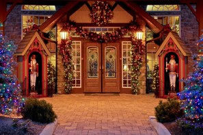Welcome to our charming hotel, featuring a traditional entrance with a wreath above the double doors and nutcracker statues on either side.