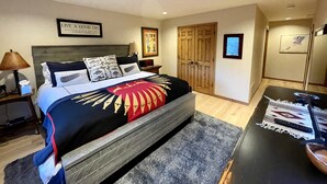 A bedroom with a bed, nightstands, a wooden wardrobe, a desk with a chair, and a framed quote on the wall. - Exclusive Teton Pines Home off Teton Village Rd. 5 min from Teton Village Skiing (Wilson)