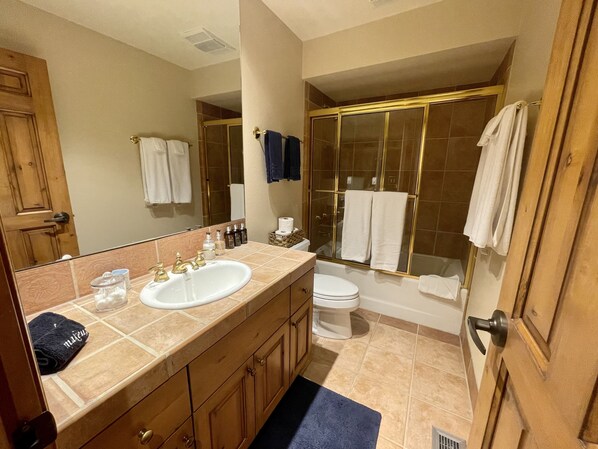 A bathroom with a sink, toilet, and shower.