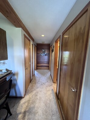Stroll down this elegant hallway, lined with doors and a comfortable workspace.