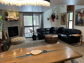 Relax in this stylish living room with a cozy fireplace, comfortable sofa, and a large window offering a view of the outdoors.