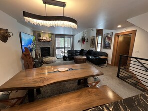 Cozy living room with a large dining table, comfortable seating, and a fireplace.
