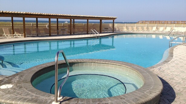 A swimming pool with a hot tub, lounge chairs, and a wooden deck. - HIDDEN GEM 1BR/1BA BEACH PROPERTY AT JETTY EAST, DESTIN , FLORIDA  (Destin)
