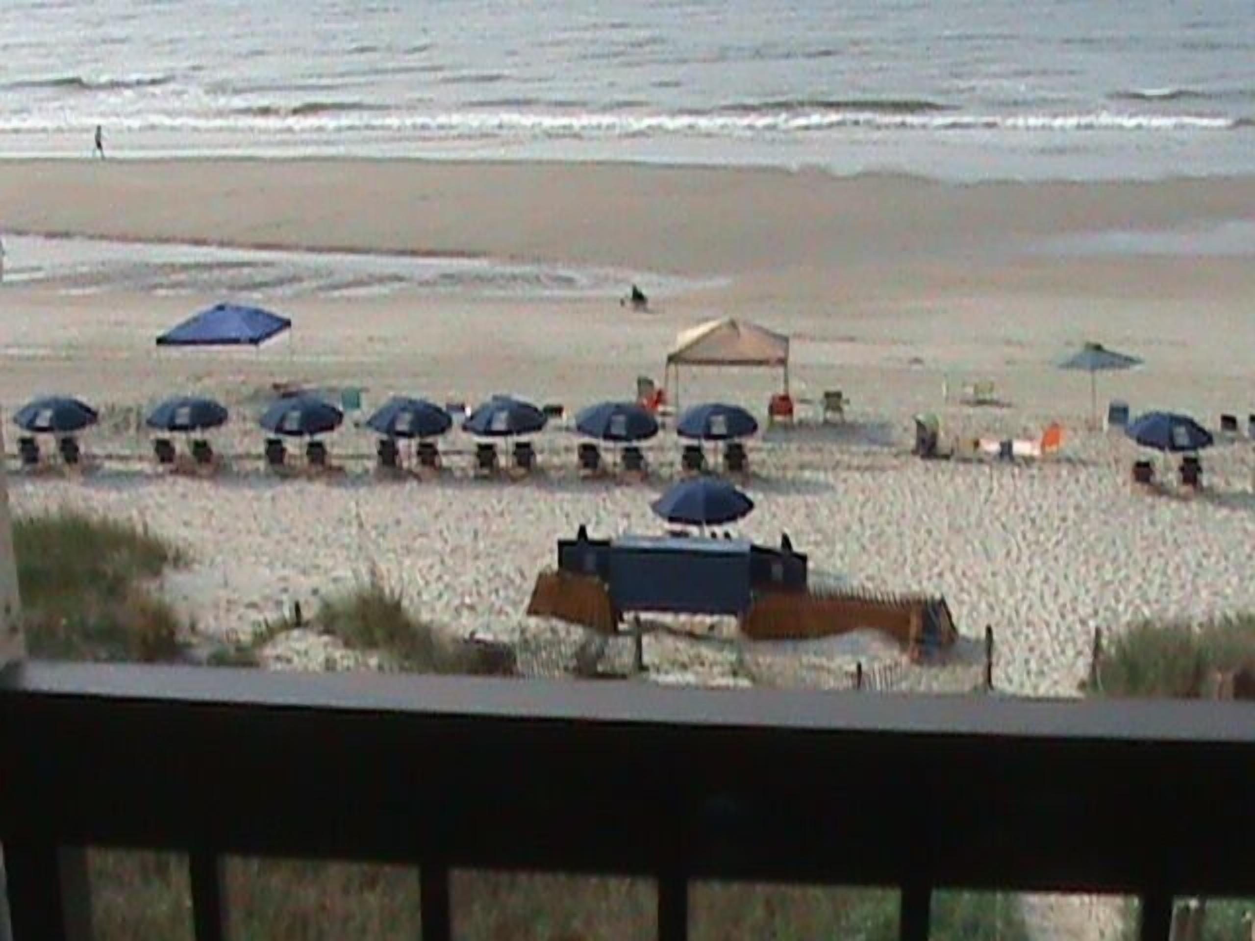 A beach with umbrellas and lounge chairs.
