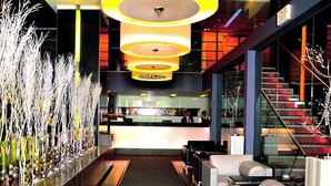 Eine moderne Lobby mit einer Rezeption, einer Sitzecke und einer Treppe.