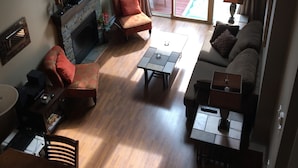 Amplia sala de estar con chimenea, televisor y comedor.